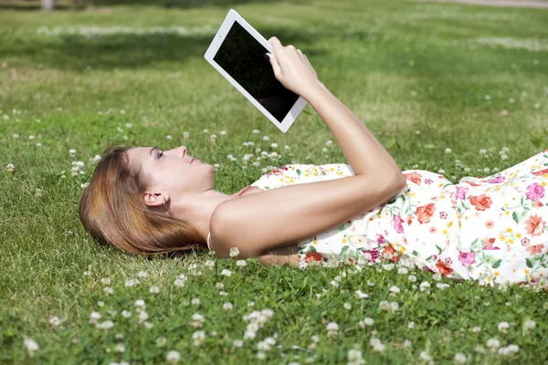 Portrait of young woman lying on a green lawn — Stock Photo, Image