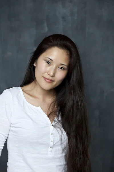 Asiatiska unga kvinna som står vid väggen — Stockfoto