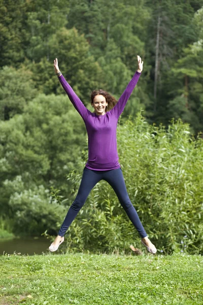Счастливая молодая женщина прыгает в летний день — стоковое фото