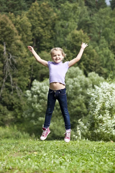 Happy little girl jumping in summer day — Stock Photo, Image