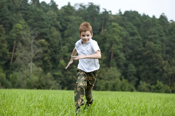 Niño corriendo en el prado en el día de verano — Foto de Stock