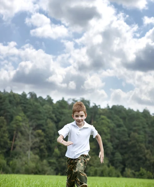 Little boy running on the meadow in summer day — Stock Photo, Image