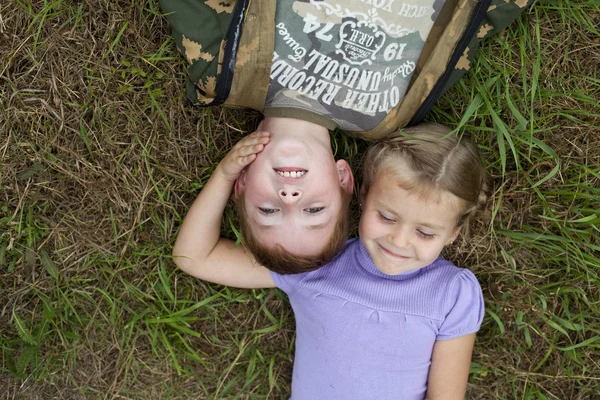 Kinder liegen auf dem grünen Rasen im Park — Stockfoto