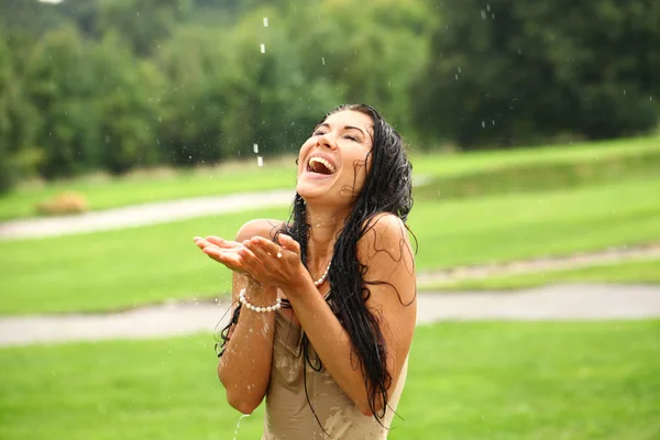 Jeune femme heureuse marchant sous la pluie — Photo