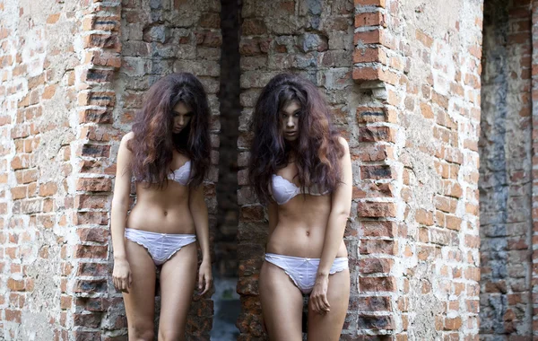 Sad women in white underwear on a brick wall — Stock Photo, Image