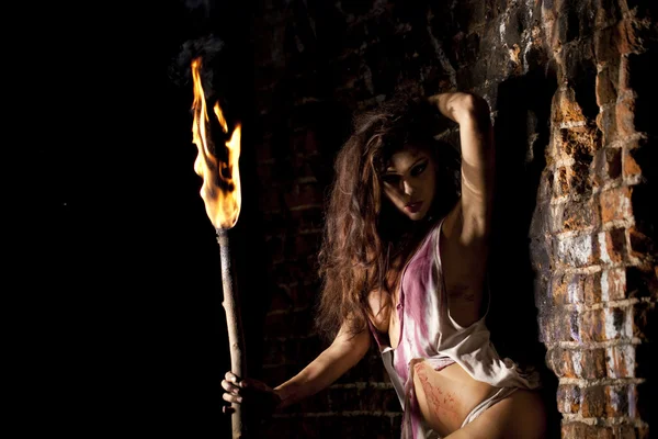 Таємнича сексуальна жінка з факелом в руці — стокове фото