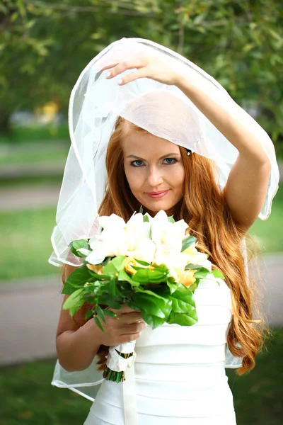 Belle mariée aux cheveux rouges portant une robe de mariée — Photo