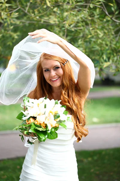 Belle mariée aux cheveux rouges portant une robe de mariée — Photo