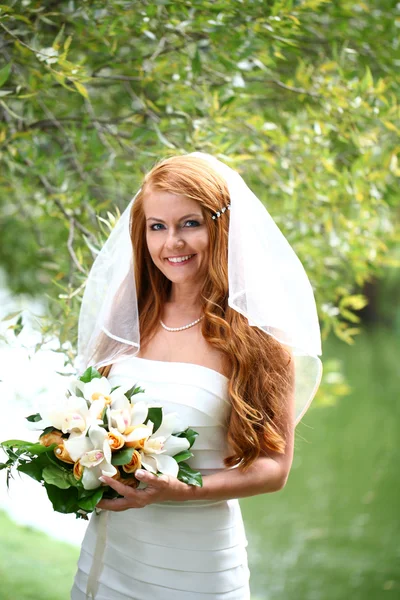 Belle mariée aux cheveux rouges portant une robe de mariée — Photo
