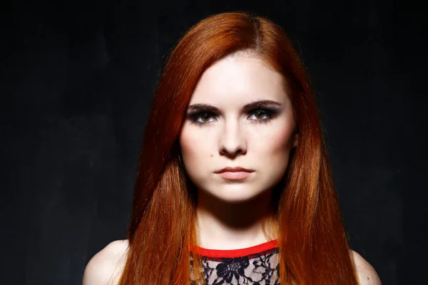 Jovem bela mulher de cabelo vermelho no estúdio escuro — Fotografia de Stock