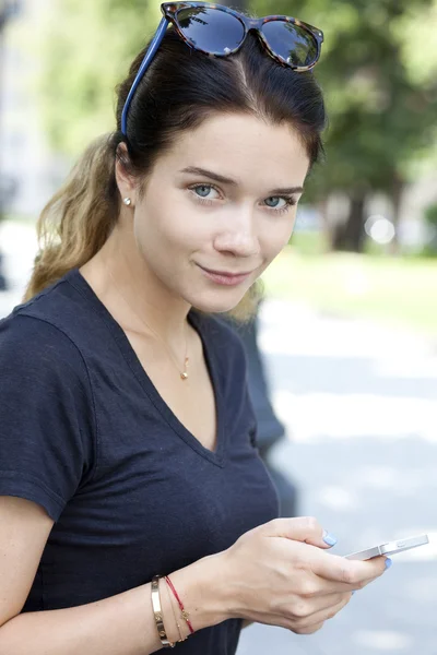 Jonge vrouw leest een bericht aan de telefoon — Stockfoto