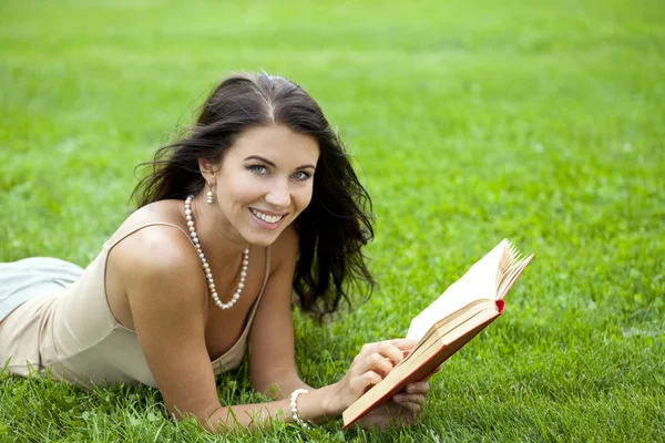 Giovane bella giovane donna che legge un libro all'aperto — Foto Stock