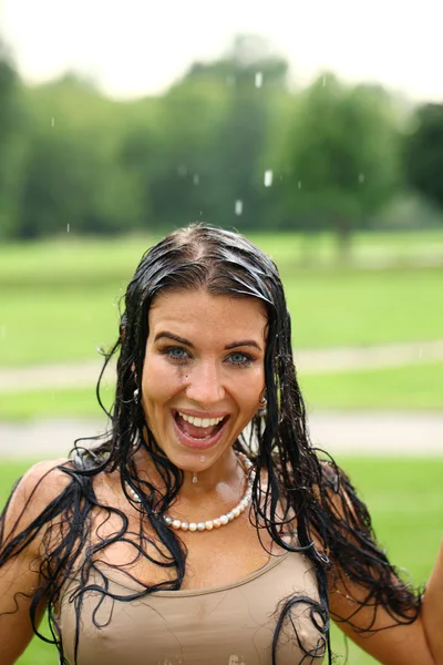 Joven mujer feliz caminando bajo la lluvia — Foto de Stock