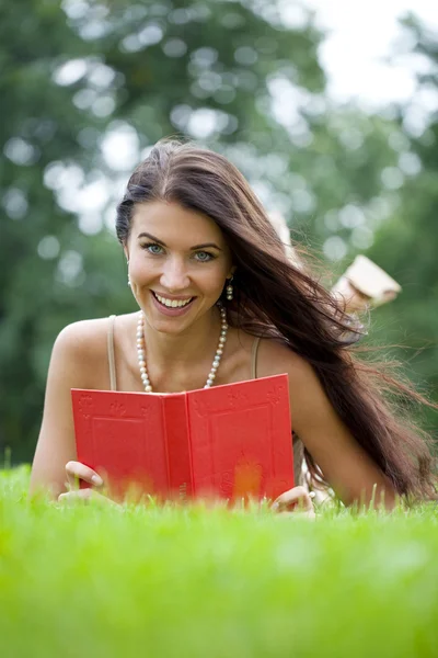 Νέοι όμορφη νεαρή γυναίκα διαβάζοντας ένα βιβλίο εξωτερική — Φωτογραφία Αρχείου