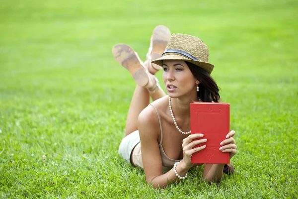 Νέοι όμορφη νεαρή γυναίκα διαβάζοντας ένα βιβλίο εξωτερική — Φωτογραφία Αρχείου