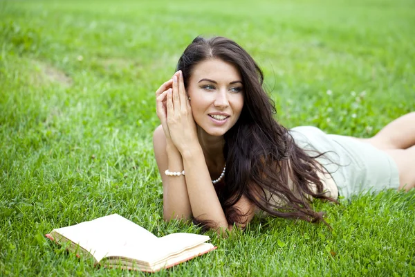 Jeune belle jeune femme lisant un livre en plein air — Photo