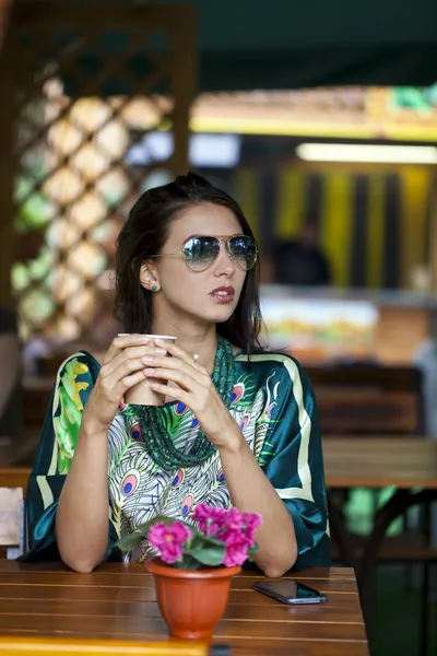 Young woman sitting in the cafe with a cup of tea — Stock Photo, Image