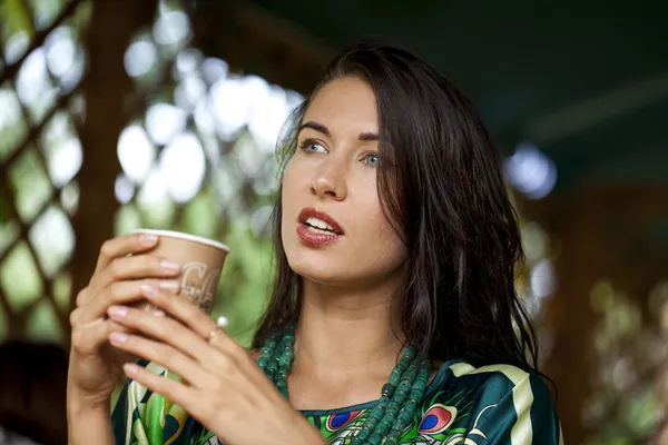 Mujer joven sentada en el café con una taza de té — Foto de Stock