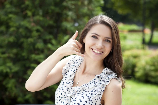 Woman making a call me sign outdoors — Stock Photo, Image