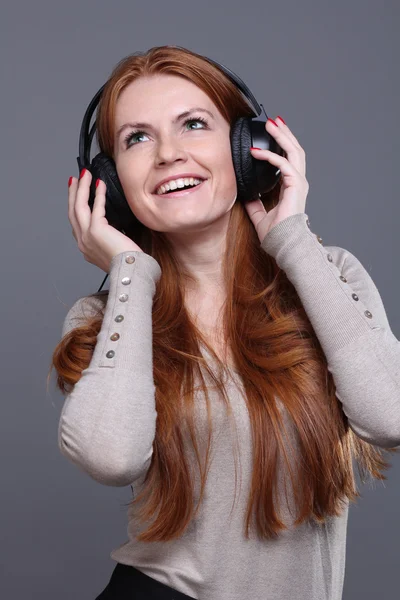 Ung kvinna lyssnar på musik — Stockfoto