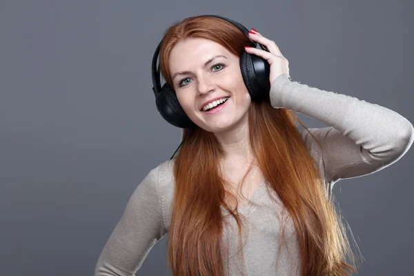 Ung kvinna lyssnar på musik — Stockfoto