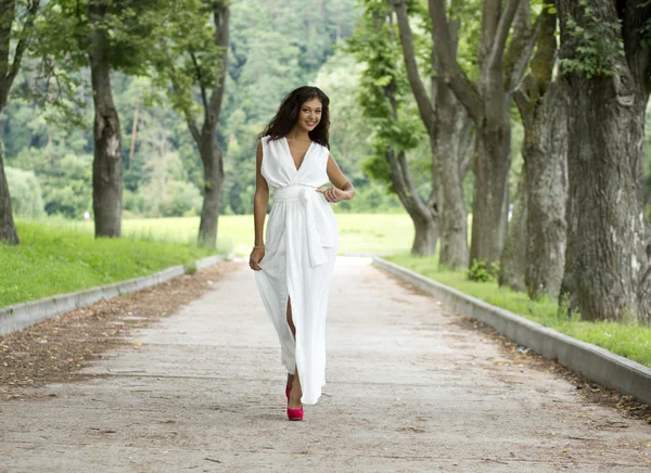 Happy young woman walking on the summer park — Stock Photo, Image