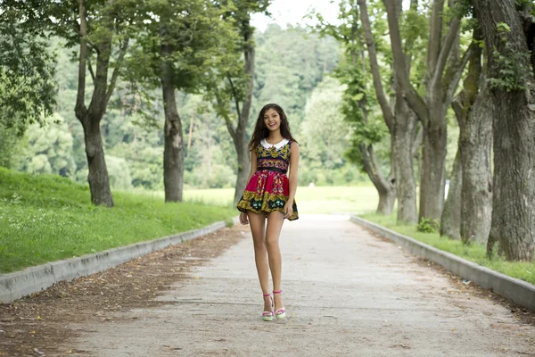 Счастливая молодая женщина, гуляющая по летнему парку — стоковое фото