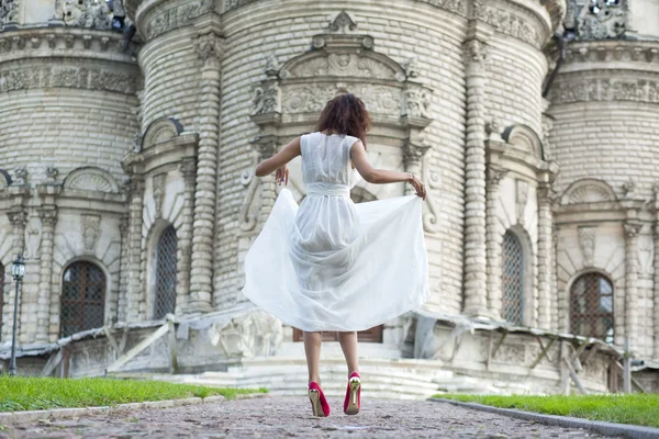 Jovem mulher em um vestido longo branco — Fotografia de Stock