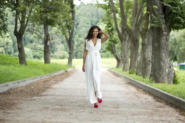 Щаслива молода жінка, що гуляє на літньому парку — стокове фото