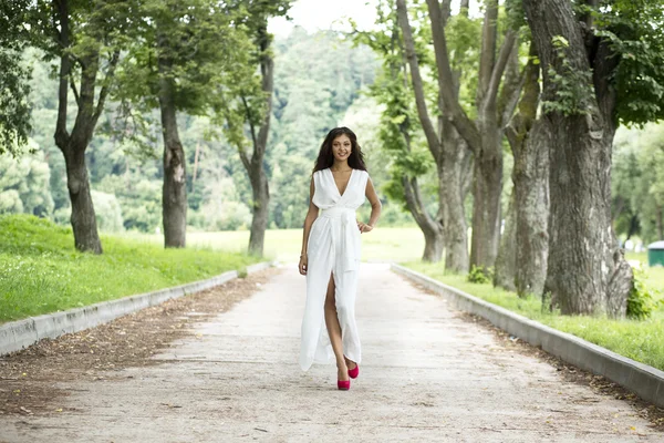 Happy young woman walking on the summer park — Stock Photo, Image