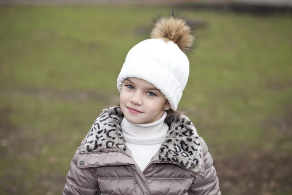 Маленька дівчинка в білому в'язаному капелюсі осінь — стокове фото