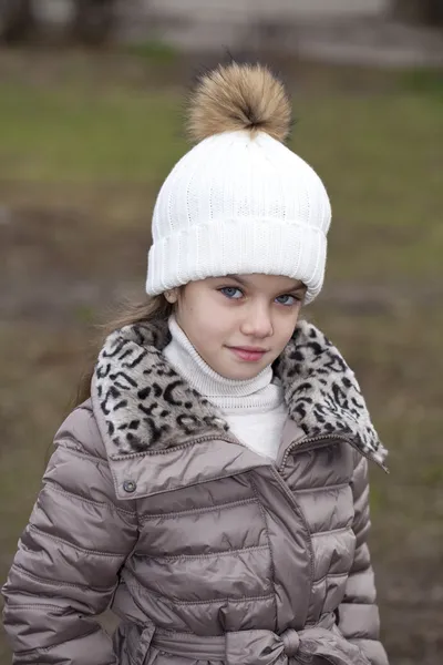 Маленька дівчинка в білому в'язаному капелюсі осінь — стокове фото