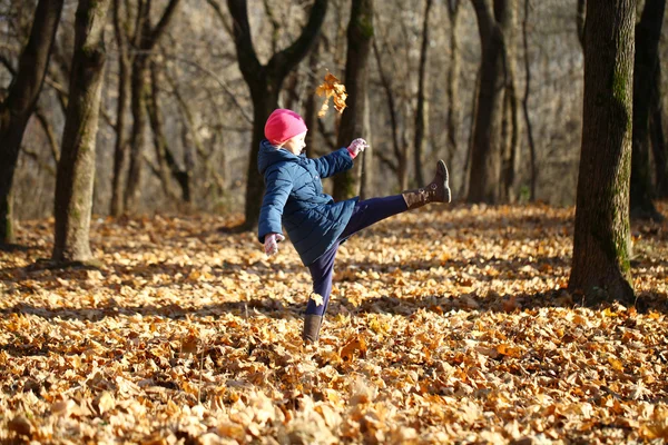 Маленькая девочка в белой вязаной шляпе осенью — стоковое фото