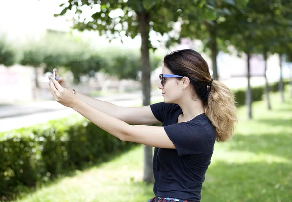 Молодая женщина фотографирует на телефон — стоковое фото