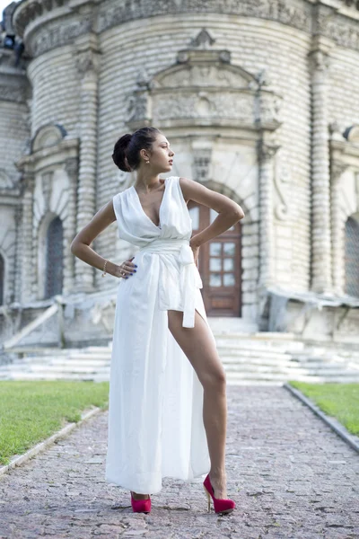 Ung kvinna i en vit lång klänning — Stockfoto