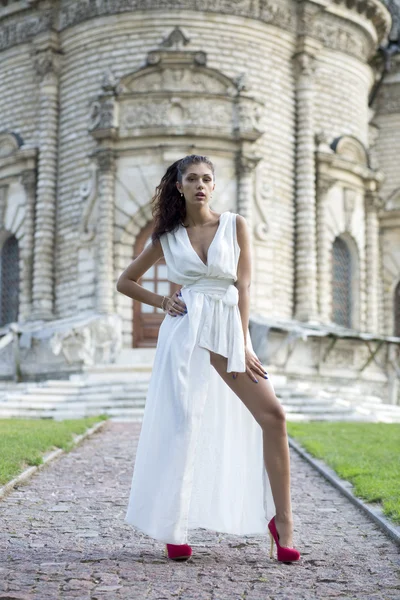 Giovane donna in un abito lungo bianco — Foto Stock