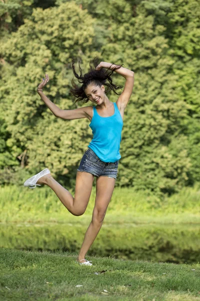 Mooi meisje te springen van vreugde in een zomer park — Stockfoto