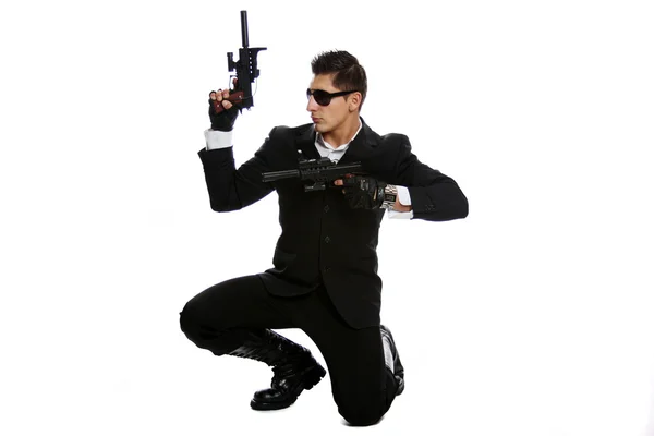 Män i svart kostym håller gun — Stockfoto