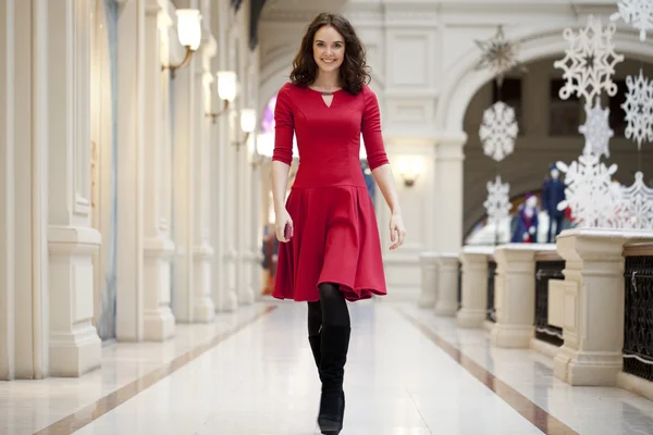 赤いドレスの若い美しい女性、ストアに歩く — ストック写真