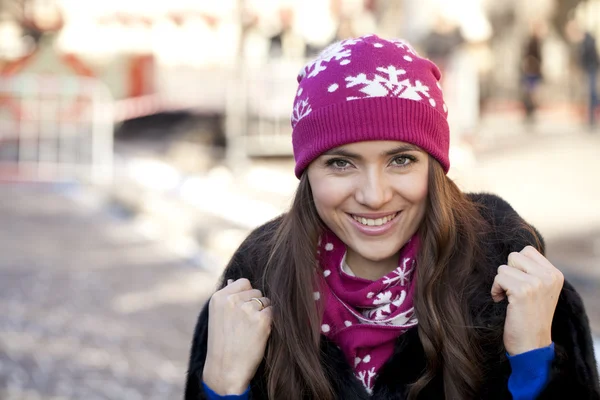 Mujer joven feliz en un fondo de una ciudad de invierno — Foto de Stock