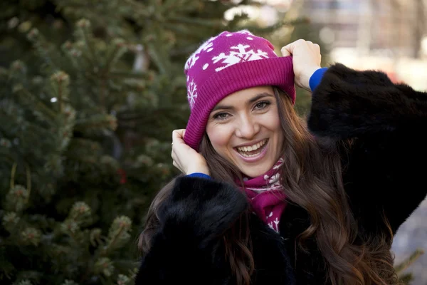 Mujer joven feliz en un fondo de una ciudad de invierno — Foto de Stock