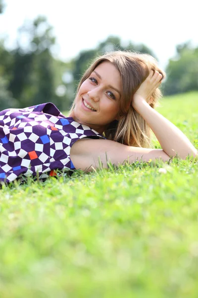 젊은 여자는 녹색 잔디에 누워 — 스톡 사진