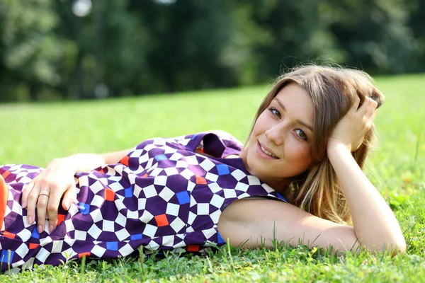 Młoda kobieta, leżąc na zielony trawnik — Zdjęcie stockowe