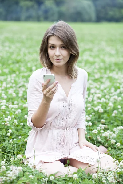 Молода жінка фотографує ваш телефон — стокове фото