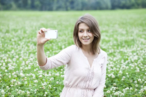 Jovem mulher tirando fotos em seu telefone — Fotografia de Stock