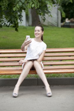 genç kadın bir bankta oturur.