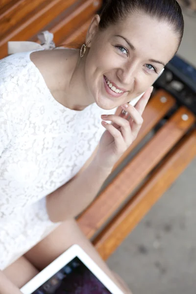 Jeune femme assise sur un banc — Photo