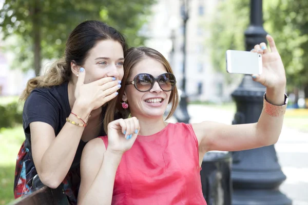 Cep telefonu bir parkta bir bankta oturan genç kız gülümseyerek — Stok fotoğraf