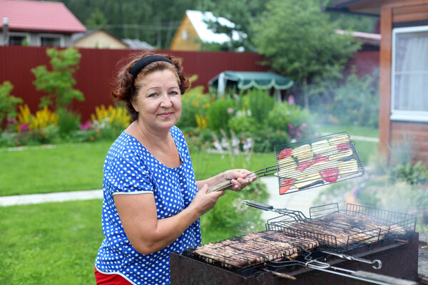 Woman Cooking On A Barbeque in the garden