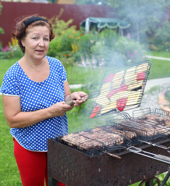 woman Cooking On A Barbeque in the garden